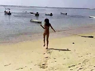 Monika Fox poses seductively in pink bikini on sunny beach.