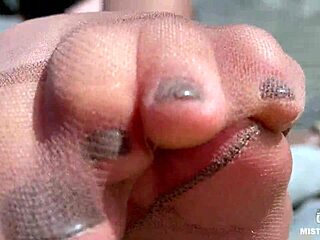 Goddess contrasts tan nylons with cute soles and toes teasing by the riverside outdoors