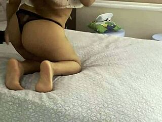 In a homemade scene, a Latina with big tits and ass moves sensually on the bed with a massive cock.