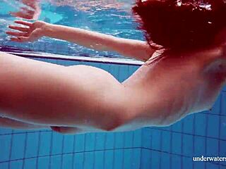 Martina shows off her tight pussy in a blue bikini during an underwater swim at the pool.