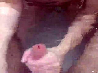 In the bath, she gave a close-up handjob to her boyfriend's big cock. It ended with a hot underwater cumshot explosion.