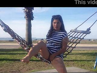 naked brunette bends over public beach