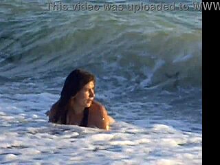 naked brunette bends over public beach