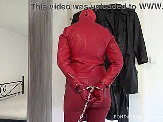 Red Leather Hooded Wife Bound In Handcuffs And Chains