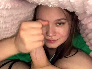 young brunette sneaks under blanket for deep blowjob