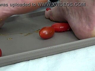 Housewife tramples ripe tomatoes under bare feet sensually