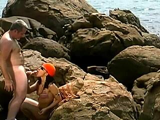mature stud fucks exotic babe's clit on seaside rocks