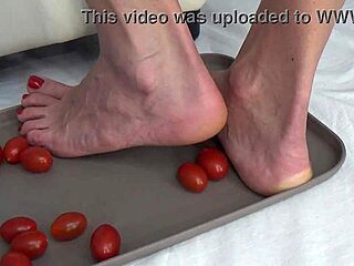 Housewife tramples ripe tomatoes under bare feet sensually
