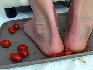 Housewife tramples ripe tomatoes under bare feet sensually