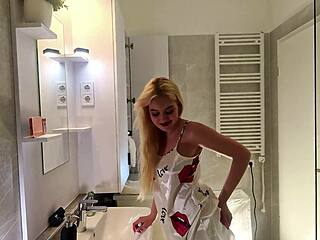 Watch this sexy blonde coed tease her satin-clad body in bathroom