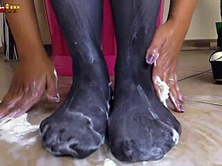 brunette in pantyhose gives footjob to cream tube
